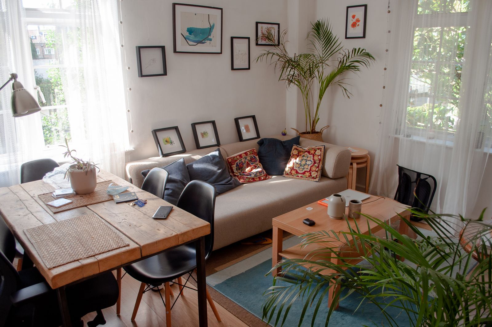 Bright cozy living room with plants, thrifted furniture and warm textiles